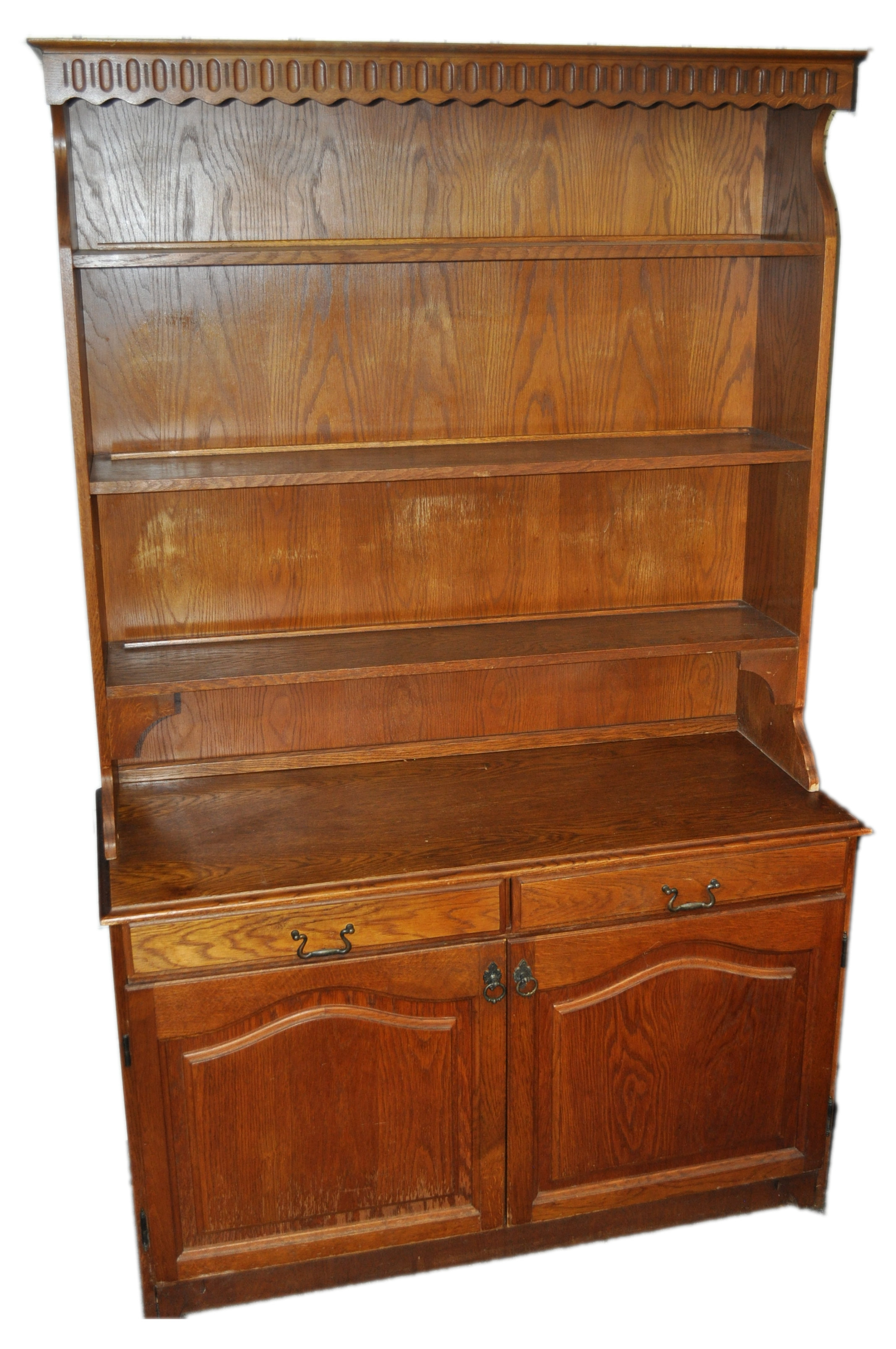 An oak dresser with three shelf top over a two door cupboard and two drawers,