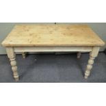 A pine kitchen table with two frieze drawers on turned legs,