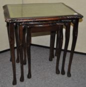 A nest of mahogany tables with inset leather tops