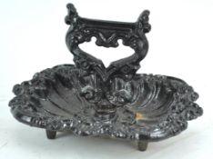 A 19th century cast iron boot scraper with dish base,