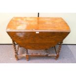 An oak gate leg table with barley twist legs,