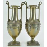 A pair of embossed neo-clasical Adam style brass vases,
