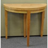 A light wood demi-lune table on three legs,