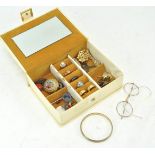 A cream jewellery box of vintage jewellery and specs