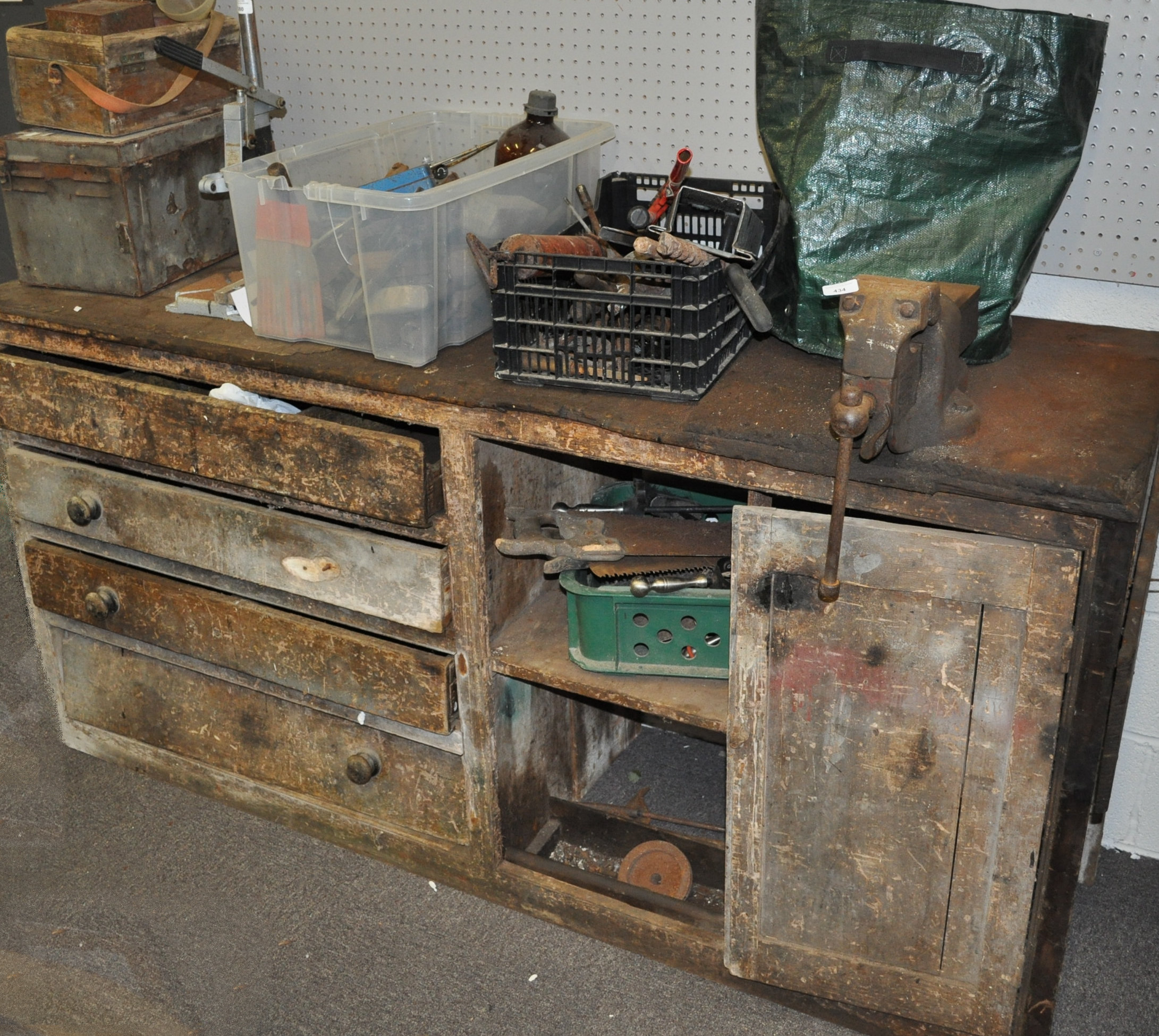 A large wood work bench set with a vice and a large selection of tools