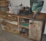 A large wood work bench set with a vice and a large selection of tools