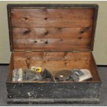 A wooden trunk containing tools and other items