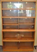 A five piece Simplex sectional bookcase in teak, with sliding glass doors 190 cm high,