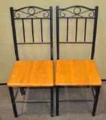 A pair of dining chairs with wrought iron backs,