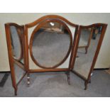 A mahogany framed triptych dressing table with oval swing frame central section on flared feet,