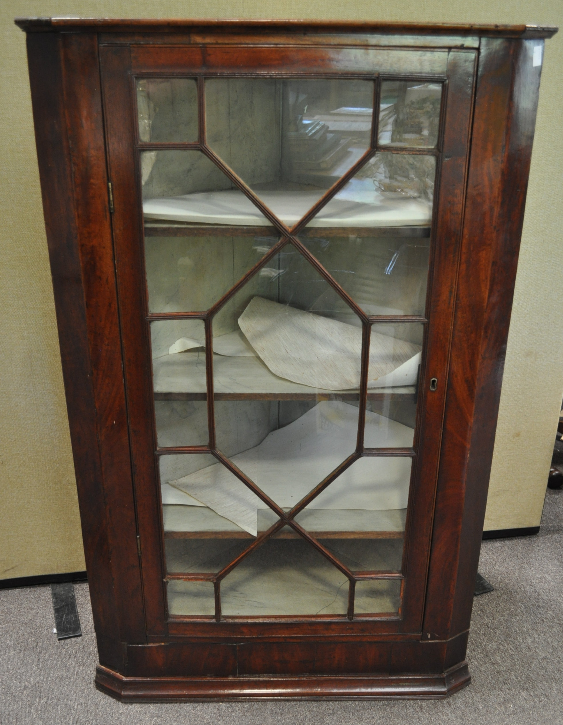 A George III mahogany hanging corner cabinet with glazed door,