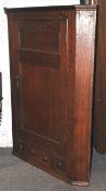 A 19th century oak corner cupboard with panel door and three drawers