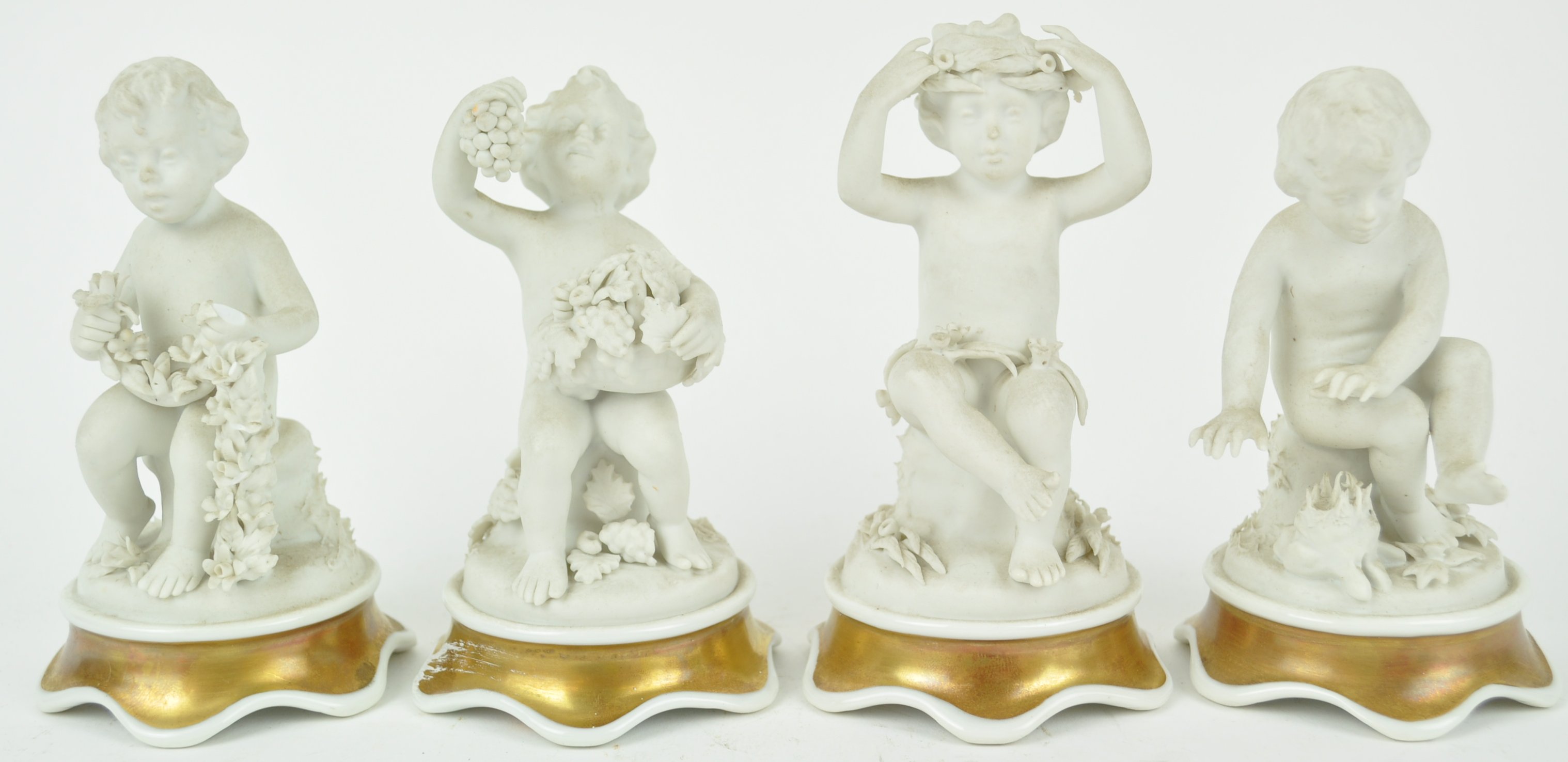 A set of four Continental bisque figures of putti depicting the Four Seasons,