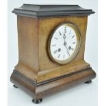 A late 19th century mantle clock, the enamel dial in walnut and ebonised case,