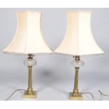 A pair of brass column table lamps with cut glass reservoirs,