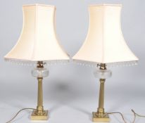 A pair of brass column table lamps with cut glass reservoirs,