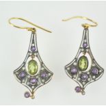 A yellow and white metal pair of abstract design drop earrings.