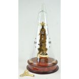 A skeleton style clock, of elongated form, striking on a bell, raised on a wood base,