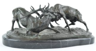 A 20th century bronze figure of two rutting stags, on black marble base, indistinct foundry mark,