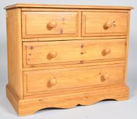 A 20th century pine chest of two short and two long drawers with turned handles and shaped plinth