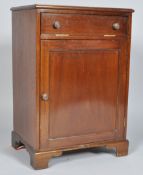 A mahogany side cabinet with one vertical hinged cupboard above a panelled door on bracket feet,