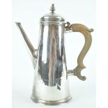 A silver coffee pot of tapered cylindrical form with urn topped raised cover and a plain spout