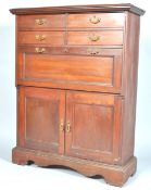 A mahogany secretaire cabinet with four drawers over a desk set with a fall front containing pigeon