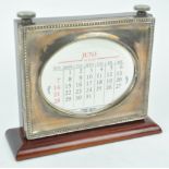 A silver mounted mahogany desk perpetual calendar