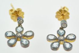 A yellow and white metal pair of drop earrings.