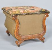 A Victorian ottoman with tapestry covered seat and carved walnut frame, on casters,