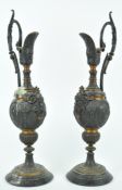 A pair of gilt bronze candlesticks, each in the form of ewers with scroll handles,