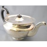 A round silver teapot, of very plain form,