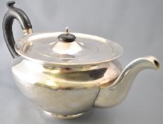 A round silver teapot, of very plain form,