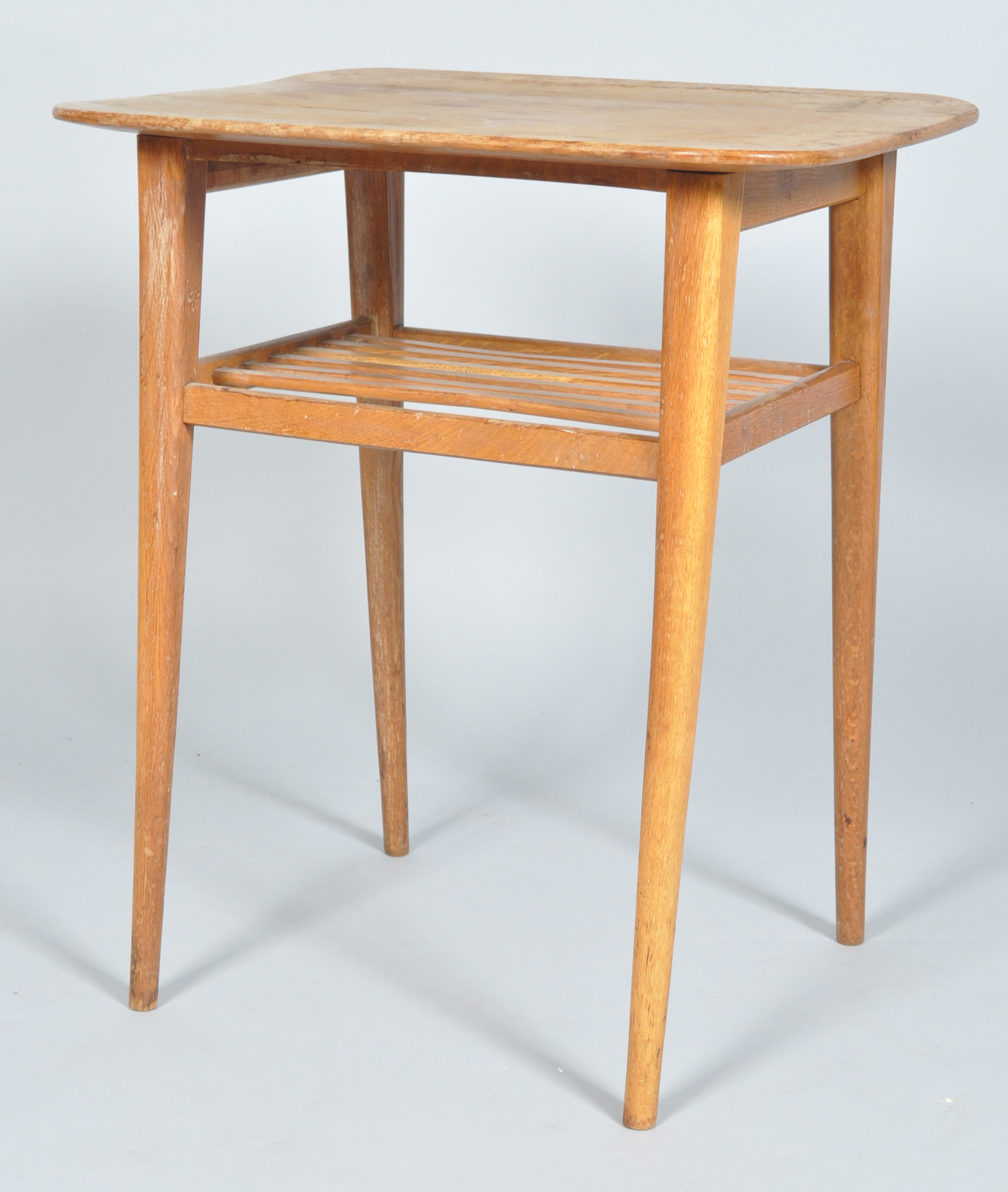 A mid 20th Century 1950's golden oak side table having a flared top above a slatted undertier and
