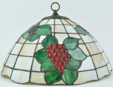 A large Tiffany style pendant light shade, decorated with bunches of grapes in foliage,