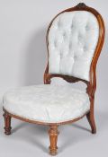 A Victorian mahogany framed nursing chair with button back above a stuff over seat