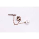 A tie pin set with a 8mm white cultured pearl together with a strand of graduated simulated pearls