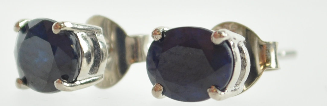A white metal pair of single stone stud earrings. - Image 2 of 3
