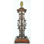 A Chinese rosewood lamp, of carved and pierced form on rectangular base with four flared feet,