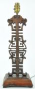 A Chinese rosewood lamp, of carved and pierced form on rectangular base with four flared feet,