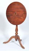 A mahogany tilt top table, the round top inlaid with brass,