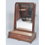 A 19th century mahogany swing mirror having shaped glass supports and acorn finials,