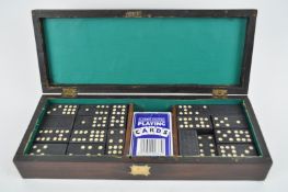 A rosewood and brass inlaid box containing a set of dominoes and playing cards,