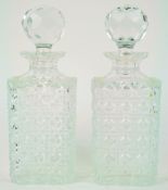 A pair of cut glass square decanters and stoppers, each with a star cut base,