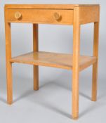 A 1950's golden oak side table with single drawer with knob handles to top and lower shelf tier