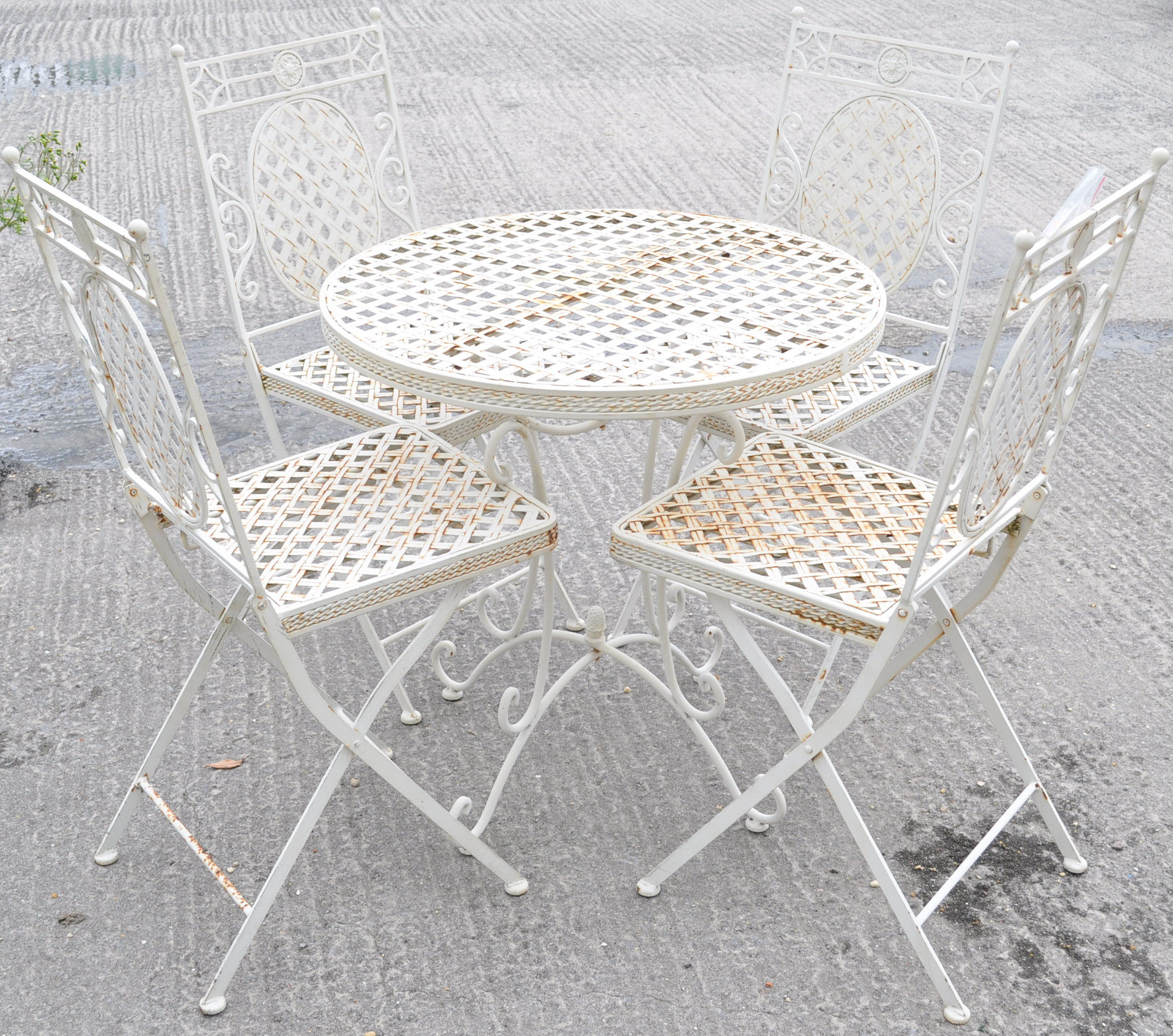 A garden table and set of four matching folding chairs with lattice top, seats and chair backs,