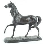 A bronze horse in naturalistic pose, holding a front leg aloft,