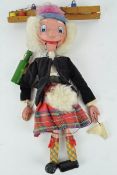 A Pelham Scotsman puppet, dressed in a kilt and holding a bottle,