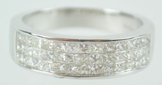 A white metal half hoop ring. Set with three rows of princess cut diamonds.