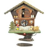 A 20th century Cuckoo clock of Swiss Chalet exterior form the doors opening to reveal a cow,